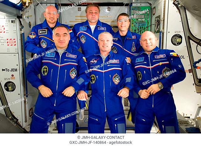Expedition 40 crew members pose for an in-flight crew portrait in the Harmony node of the International Space Station. Pictured on the front row are NASA...