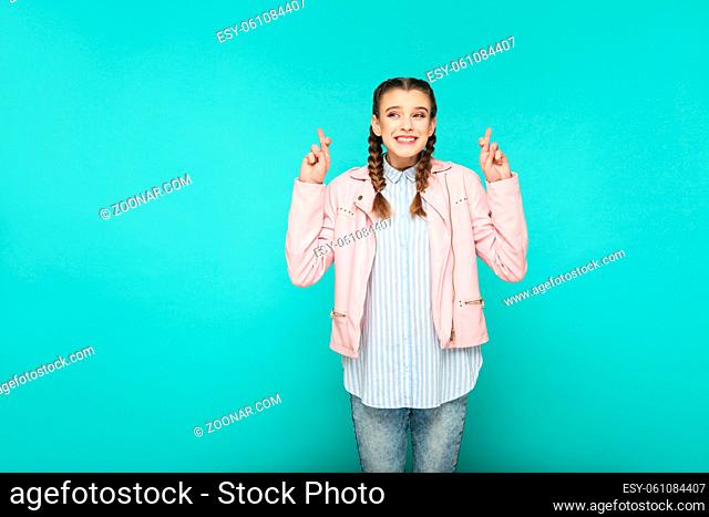 hopeful wish portrait of beautiful cute girl standing with makeup and brown pigtail hairstyle in striped light blue shirt pink jacket