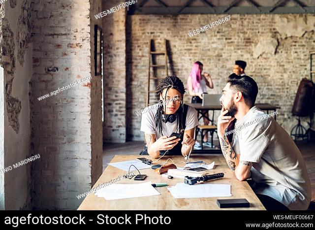 Creative team having sitting at table in loft office
