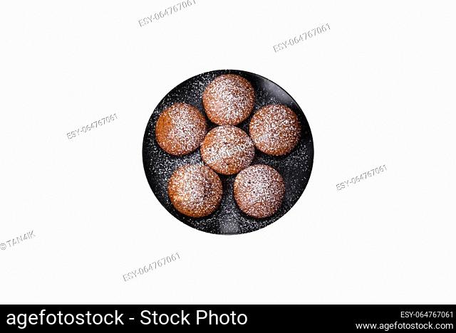 Beautiful delicious cupcakes with cocoa and raisins on a black concrete background. Time to drink tea