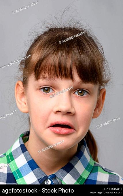 Portrait of a puzzled ten-year-old girl of European appearance, close-up