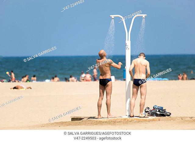 Bathers in the shower to wash off the salt and sand from the sea in Malvarrosa, Valencia, Spain, Europe