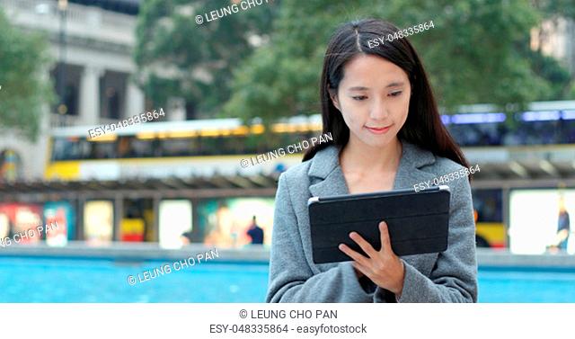 Woman using tablet computer in city
