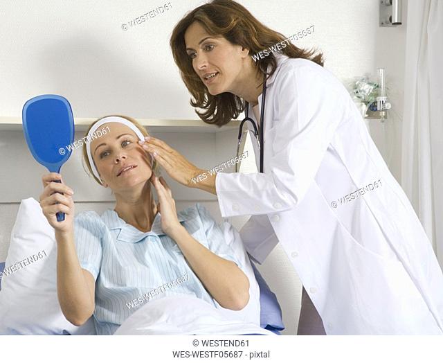 Female cosmetic surgeon talking to female patient