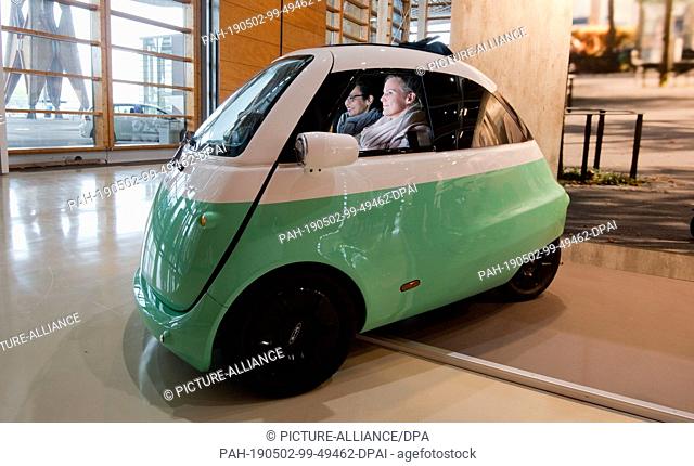 02 May 2019, Lower Saxony, Hanover: Visitors to the ""micromobility expo"" at the Hanover trade fair are seated in a microlino electric city car made by micro