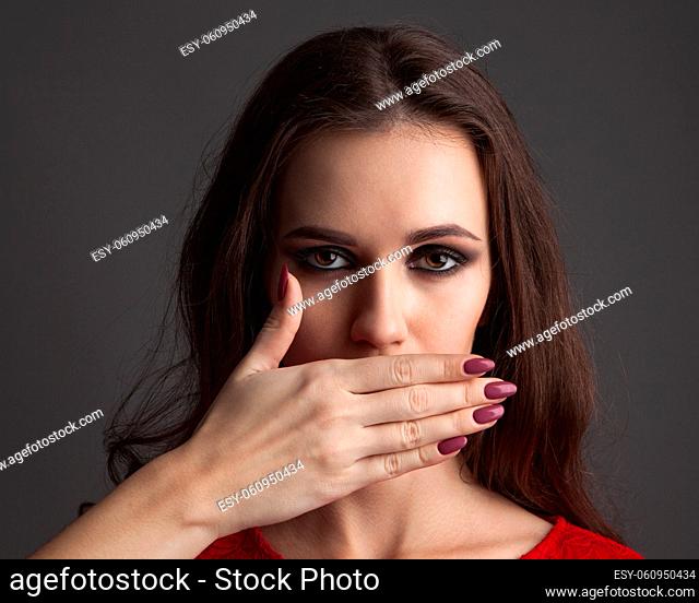 Beautiful young woman with hands on her face covering her mouth. Perfect skin, nail art and makeup