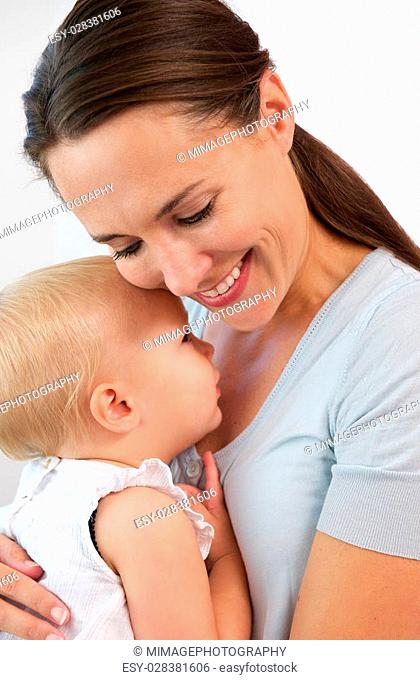 Closeup portrait of a smiling mother hugging cute baby girl
