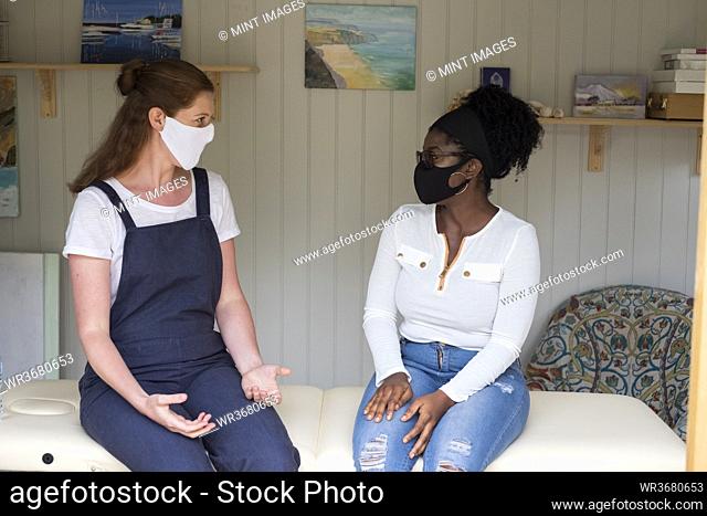 Woman and female therapist in face masks at a therapy session