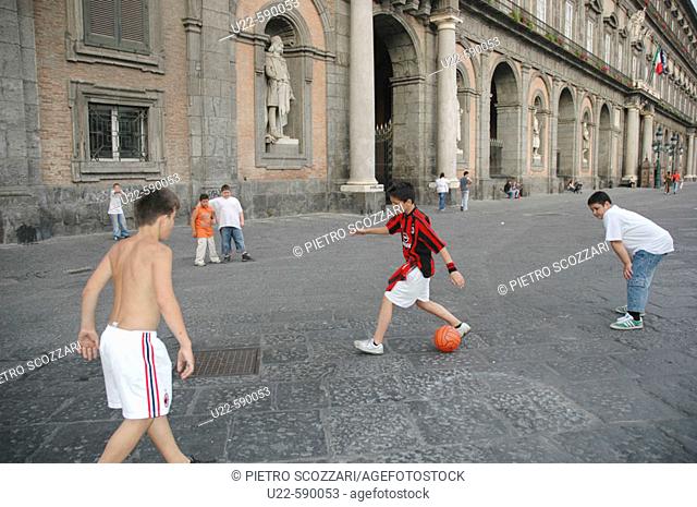 Children playing soccer in front of the Royal Palace. Naples. Italy