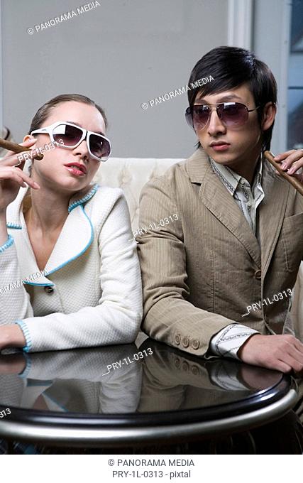 Close-up of a Young man and young woman holding cigarette