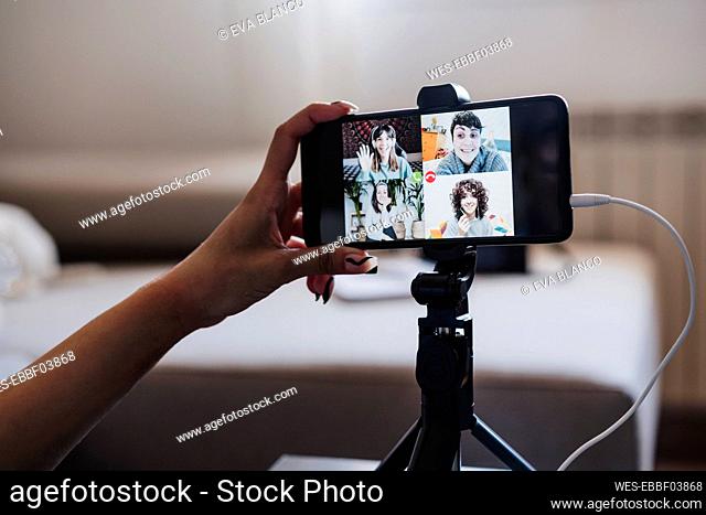 Woman video conferencing on smart phone at home