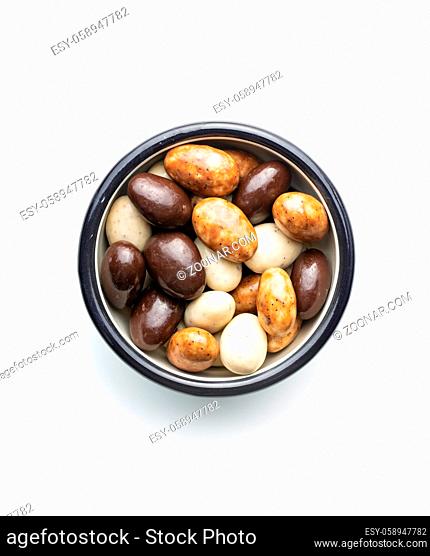 Sweet chocolate almonds in bowl. Chocolate eggs isolated on white background