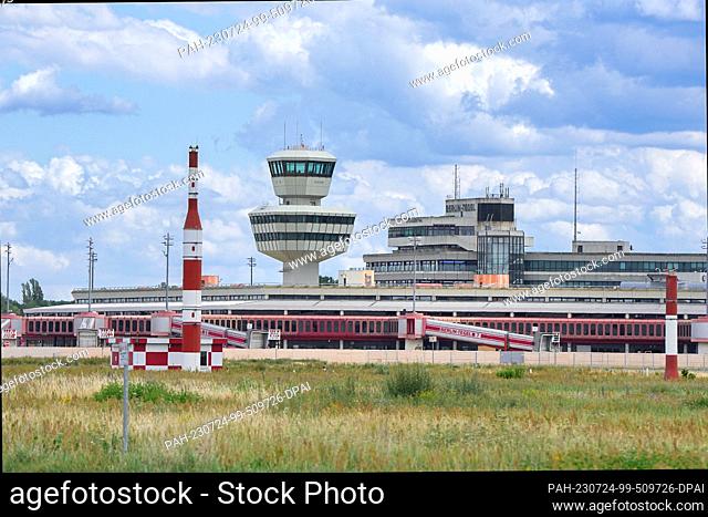 PRODUCTION - 12 July 2023, Berlin: A wooden fence has been erected around the terminal buildings and tower of the former Berlin-Tegel Airport