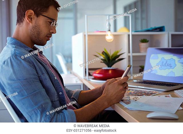 Side view of businessman using mobile phone at creative office