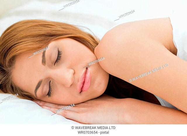 Beautiful redheaded woman sleeping in a bright room