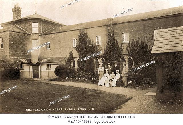 A view of the Thame Union workhouse from one of its internal yards with the workhouse chapel in the background. Posed for the photographer are what appear to be...