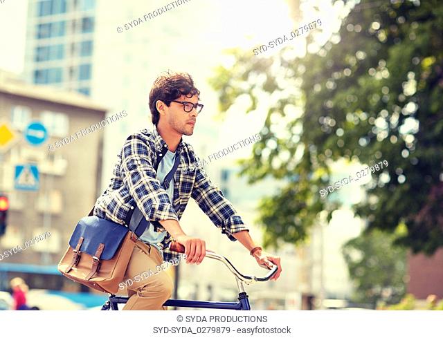 young hipster man with bag riding fixed gear bike
