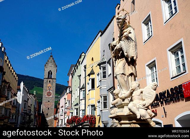 St.-Johannes-Nepomuk-Denkmal vor dem historischen Rathaus in der Neustadt von Sterzing, im Hintergrund der Zwölferturm, Südtirol, Italien