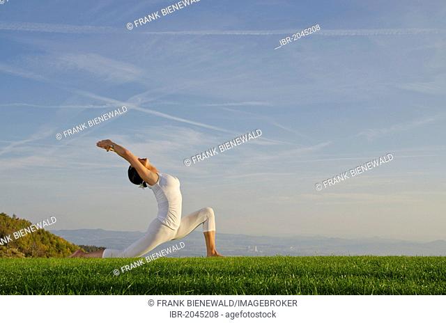 Young woman practising Hatha yoga outdoors, showing the pose anjaneyasana, chandrasana, half moon pose, Nove Mesto, Okres Teplice, Czech Republic, Europe