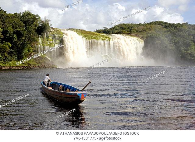 VENEZUELA GUAYANA NATIONAL PARK CANAIMA CANAIMA VILLAGE A Pemon tribe man while sailing with his boat at Canaima lake just in front of a big waterfall shoot on...