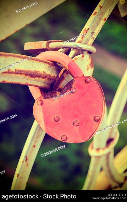 Love padlocks at a bridge while sundown. Vintage effect