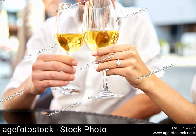 close up of couple clinking wine glasses