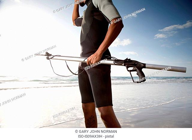 Diver with speargun on beach