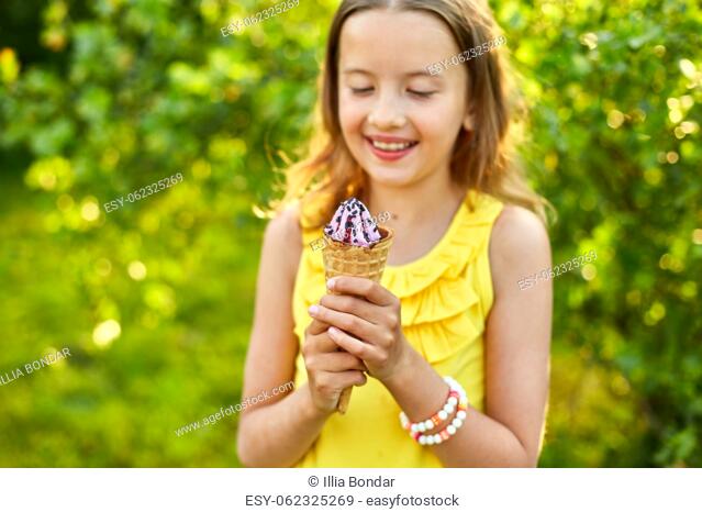 Happy girl with braces eating italian ice cream cone smiling while resting in park on summer day, child enjoying ice cream outdoor, happy holidays, summertime