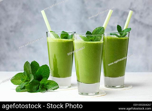 Healthy drink. Smoothies with banana, avocado, spinach, lime on a gray background