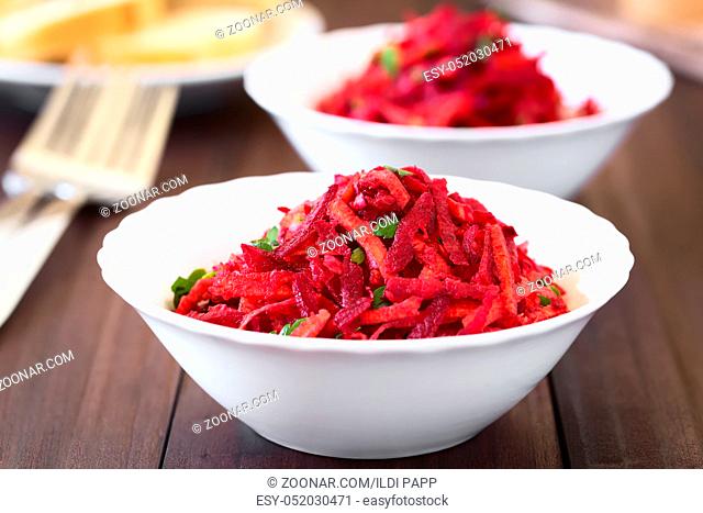 Raw grated beetroot, apple and carrot salad with parsley, photographed with natural light (Selective Focus, Focus in the middle of the image)