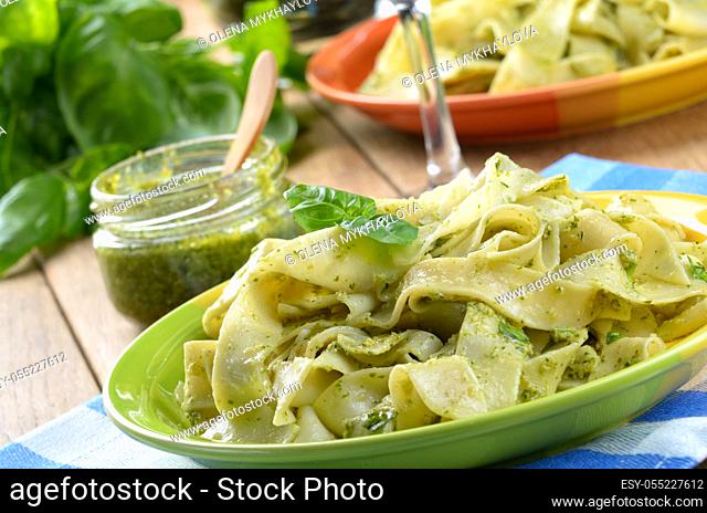 Pasta tagliatelle with pesto sauce and basil closeup shot