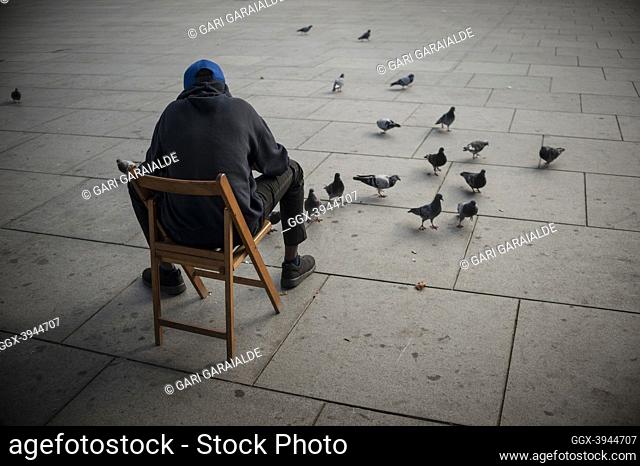 An African migrant feeding pigeons. Irun (Spain). October 23, 2018. A group of volunteers has created a host network to serve migrants and inform them about the...
