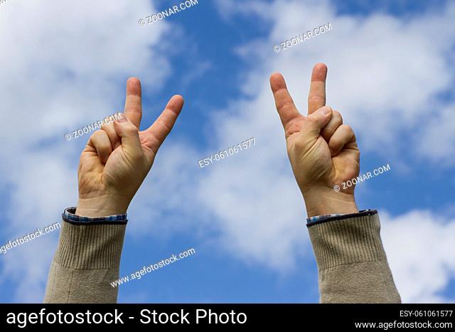 Hands up in victory on sky background