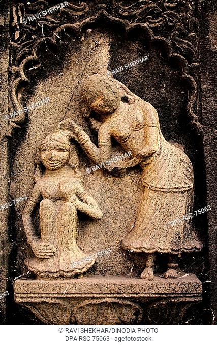 Mother and daughter , carved on the wall of Ahilayabai temple , ornamental carving over stone , old Indian sculpture , Heritage site