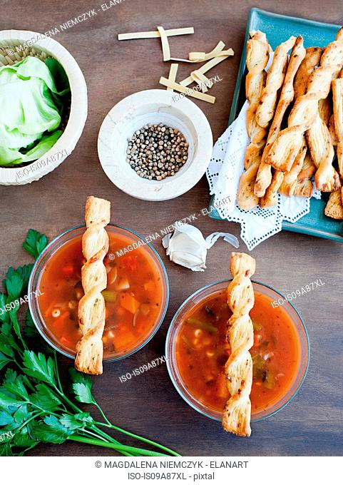Fresh vegetable soup served with breadsticks