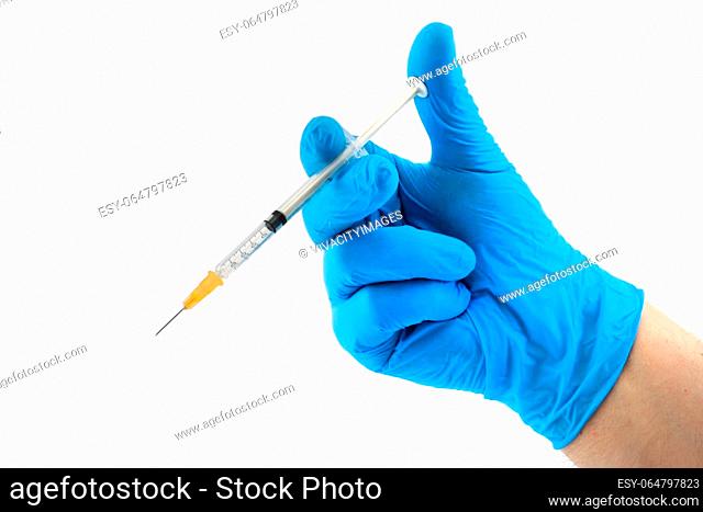 Syringe and hand in blue surgical glove ready for vaccination