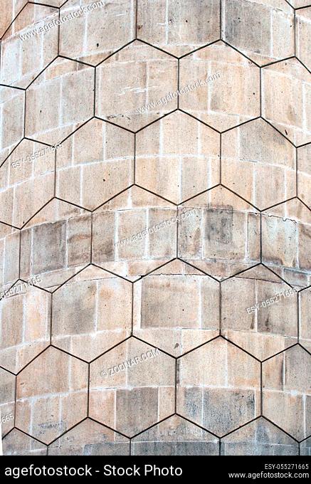 grey polygon hexagonal pattern on an old curved concrete block exterior wall