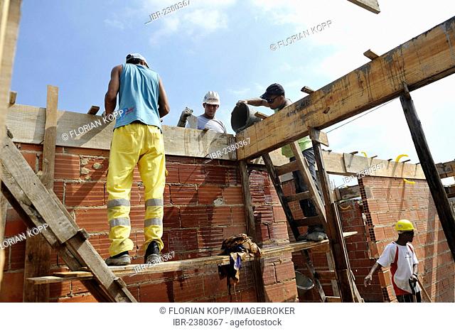 People from the slums, favelas, working together on a construction site of the Esperanca housing co-operative, each family helping out on the project and...