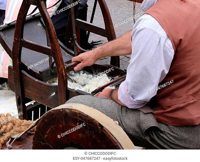 Elder carder while carding wool or cotton with old wooden machine in the carding room
