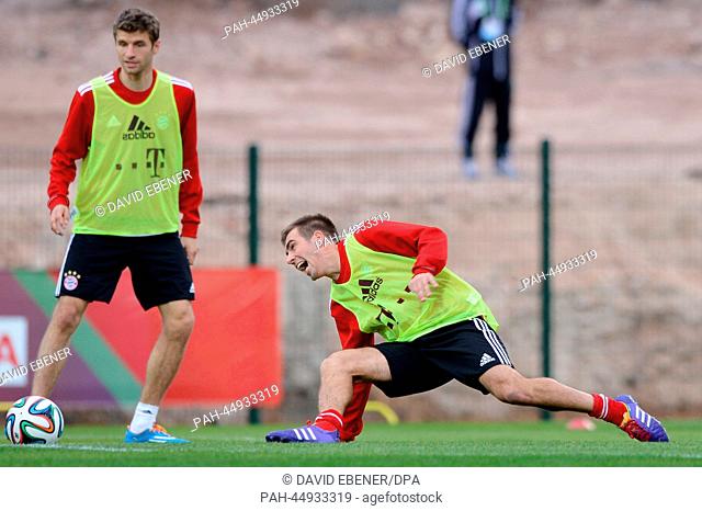 FC Bayern Munich's Thomas Mueller (L) and Philipp Lahm take part in a training session at the stadium ""Stade Adrar"" in Agadir, Morocco, 20 December 2013