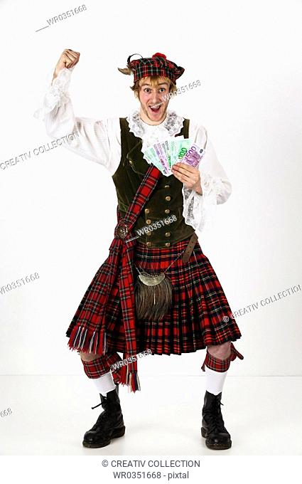cheering scotsman holding a bunch of euro banknotes