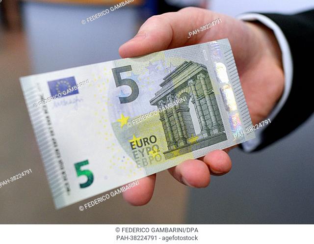 An employee of the German federal bank presents a new five euro note in Duesseldorf, Germany, 18 March 2013. The bill is the first of the second generation of...
