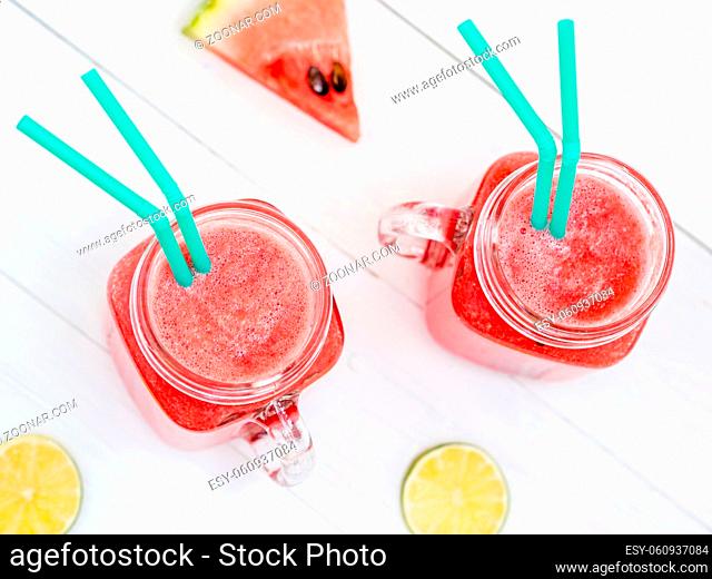 Watermelon smothie and slices on white wooden background. Top view