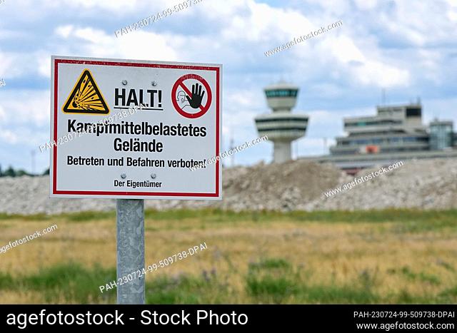PRODUCTION - 12 July 2023, Berlin: A ""Stop! Explosive Ordnance Contaminated Area"" sign stands on the site next to the runway of the former Berlin-Tegel...