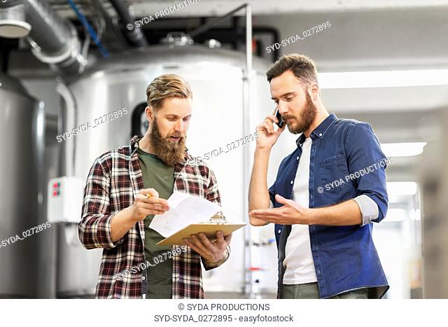 men working at craft brewery or beer plant