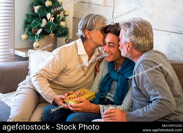 Christmas gifts moment at home with parents and grandfathers and young son or grandson - love moment and traditioal celebration for people family together -...