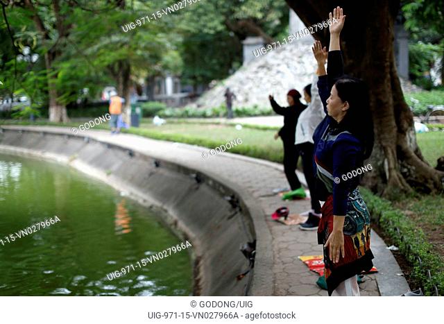 Women do Tai Chi in the morning on the banks of Hoan Kiem Lake