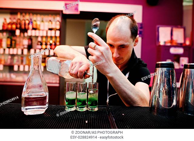Barman preparing green mexican cocktail drink at the bar