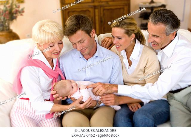 Multi-generational family smiling at baby