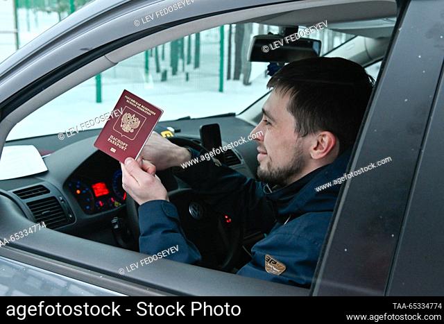 RUSSIA, MURMANSK REGION - 29 de NOVIEMBRE, 2023: Un hombre en un coche muestra un pasaporte en el cruce de automóviles Lotta en la frontera ruso-finlandés